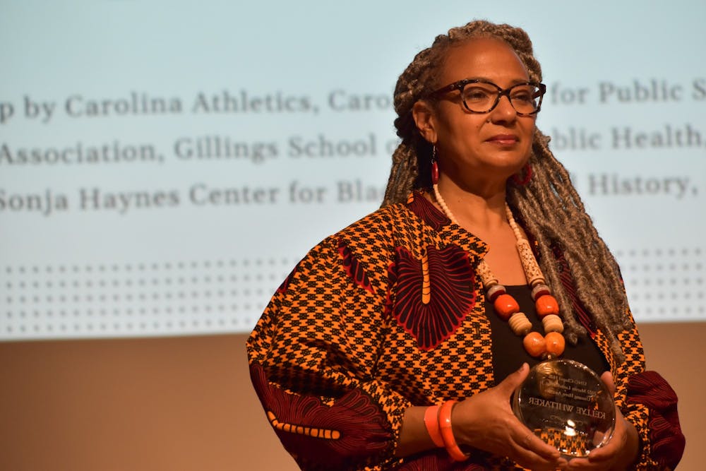<p>Kelly Whitaker receives an Unsung Hero Award in the Carolina Union on Feb. 22, 2022, during the MLK Lecture and Awards Ceremony.</p>