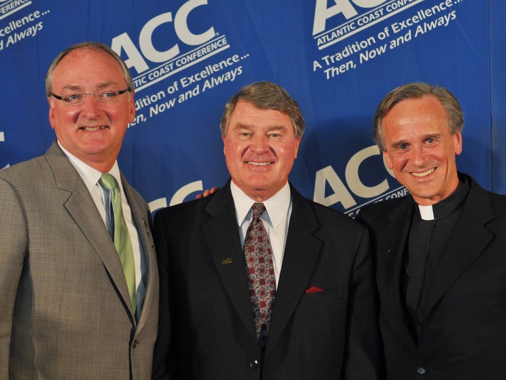 Notre Dame Reverend John Jenkins (right) and Athletic Director (left) posses with ACC Commissoner John Swafford (center).