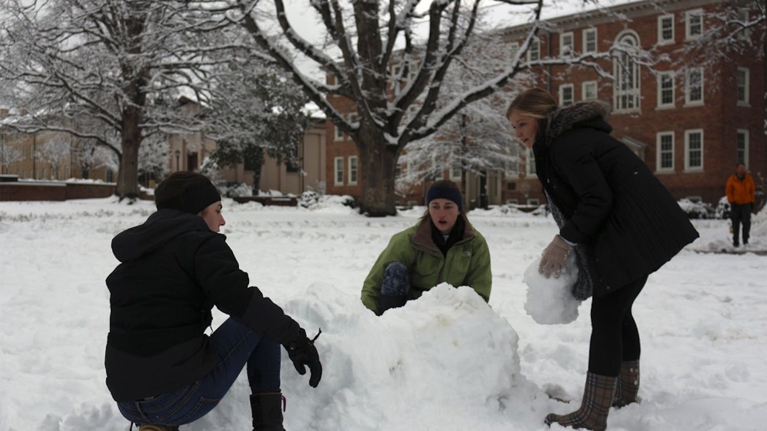 (From left to right) Megan Carlin, Sinclair McLean and Sarah Graves build an igloo on the lower quad in front of South Building on Thursday.
