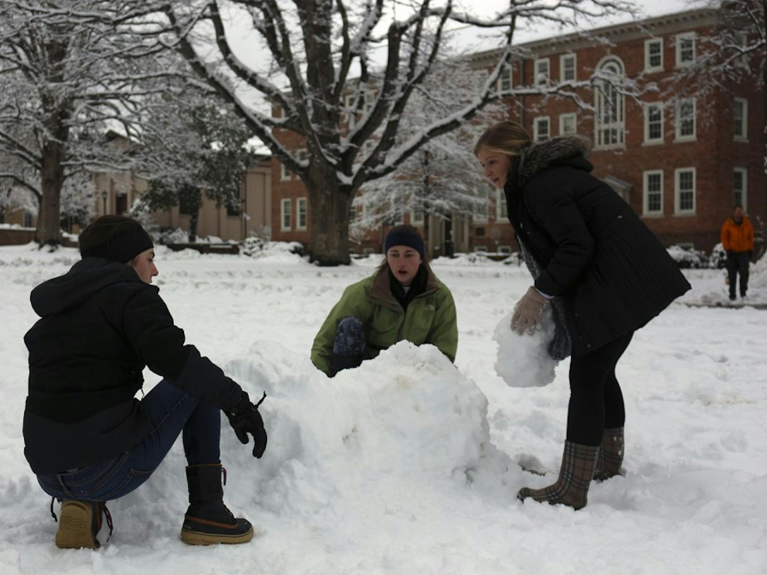 (From left to right) Megan Carlin, Sinclair McLean and Sarah Graves build an igloo on the lower quad in front of South Building on Thursday.