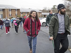 Rev. Nathan Hollister (right) leads protesters into the Estes Park Apartment leasing office Saturday morning to deliver a letter about the complex's water rates rising.