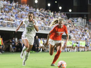 Senior forward Isabel Cox (13) sprints past a UVA player to make a shot. UNC lost to UVA at home 3-2 on Saturday, Sept. 17, 2022.