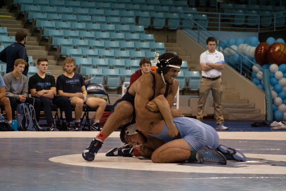 <p>Redshirt senior Ethan Ramos (in Navy) gets position over sophomore teammate Devin Kane during UNC's wrestle-offs on Oct. 27 in Carmichael Arena. &nbsp;</p>