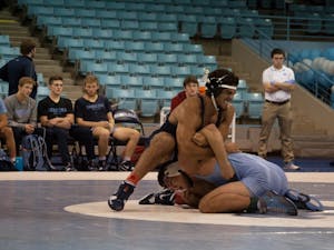 Redshirt senior Ethan Ramos (in Navy) gets position over sophomore teammate Devin Kane during UNC's wrestle-offs on Oct. 27 in Carmichael Arena. &nbsp;