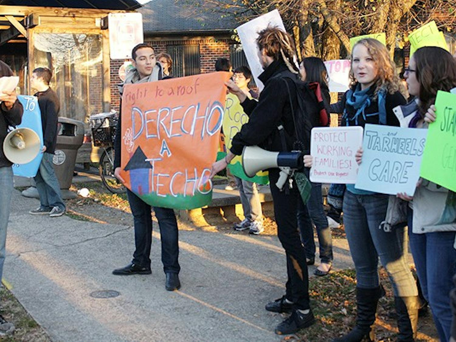 A local activist and resident of the Collins Crossing Complex leads students in protest against the rising cost of living. 