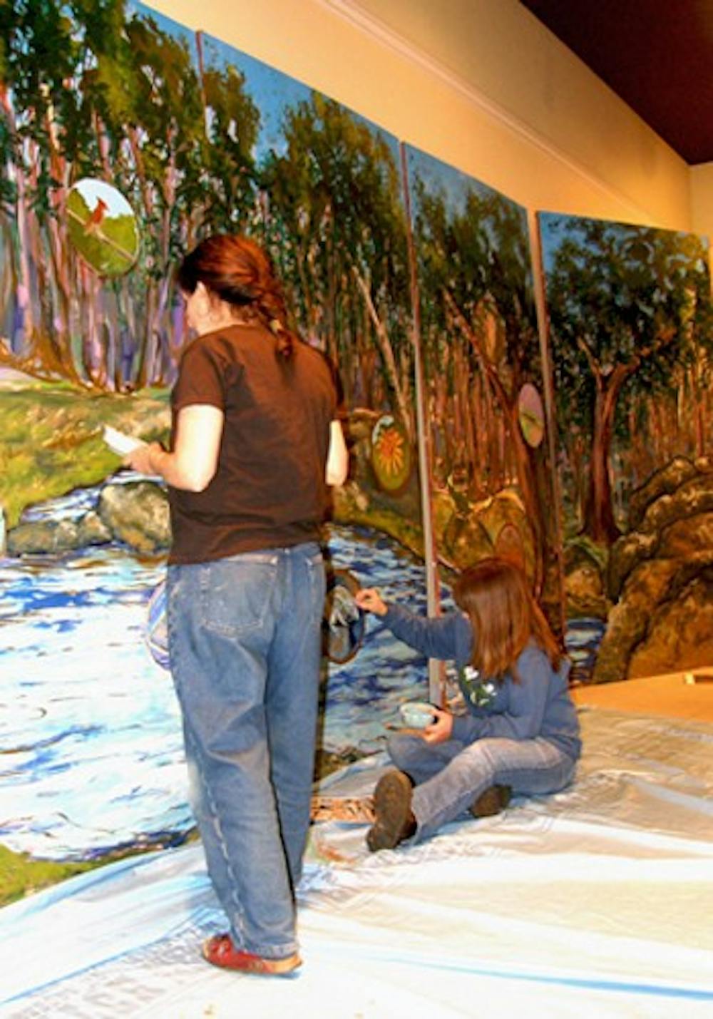 From left, Emily Weinstein and Dale Morgan work on a mural that will be shown at Earth Day festival. Courtesy of Dave Otto