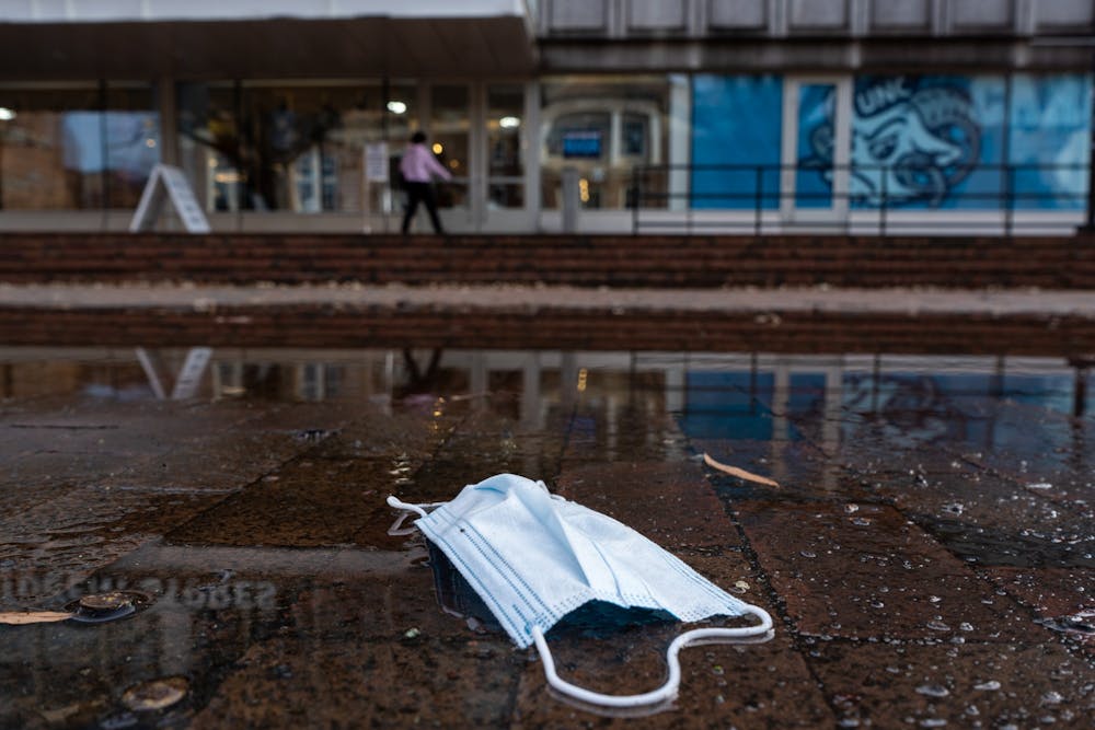 <p>A mask lies in a puddle in front of the Student Stores Building in January.</p>