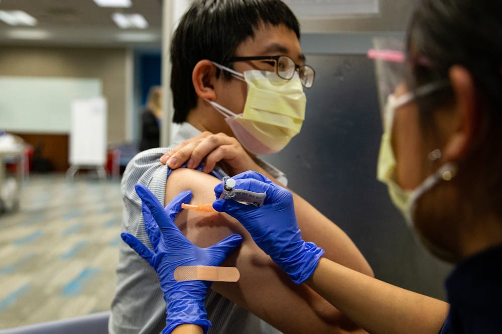 <p>Chapel Hill resident Kuan-Yi Lu recieves the first dose of the Pfizer COVID-19 vaccination at the Friday Center on Mar. 22. Thousands of vaccines are administered by medical students and nurses every day.</p>