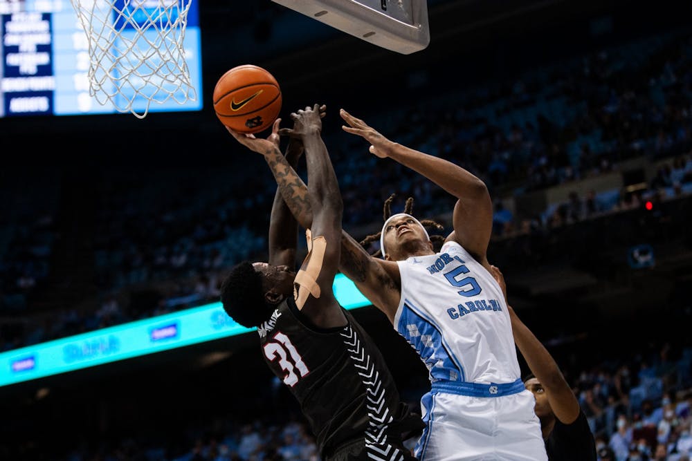 Junior forward Armando Bacot (5) stretches toward the net in an attempt to dunk the ball during a game against Brown at the Smith Center on Nov. 12. The Tar Heels defeated Brown 94-87, earning their second win of the season.