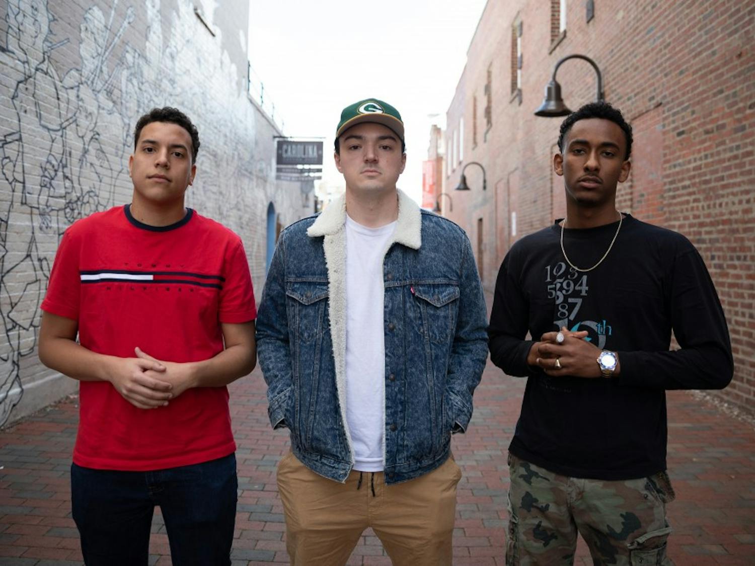 Seniors Nicho Stevens (left), Chris Coogan (middle), and Jemal Abdulhadi (right) of the UNC Student Hip Hop Organization (UNC SHHO) pose for a portrait on Friday, Jan. 18, 2018 in the alley next to Carolina Coffee Shop located on Franklin Street in Chapel Hill, North Carolina. Abdulhadi (right) discussed his experiences as a hip hop artist in lieu of the #MeToo movement which began in October of 2017.
