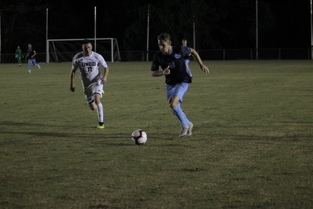 <p>Midfielder Jack Skahan (8) competes for the ball against UNC-W Ben Fisher (11) during the men's soccer game on Tuesday, Oct. 2 2018 at WakeMed Soccer Park. Skahan scored the only goal of the game, for a final score of 1-0.</p>