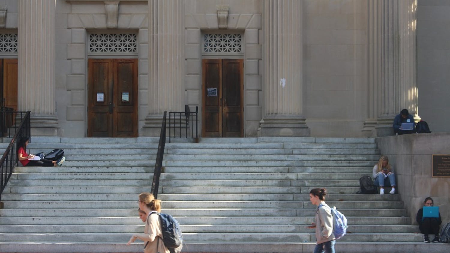 students studying on the steps of wilson library 