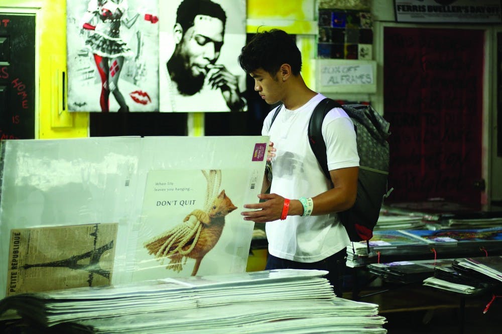 CJ Alfonso, a junior majoring in global studies and public policy, browses the poster sale at the Teen Center on Rosemary St. This poster sale has opened the UNC school year for over twenty years.