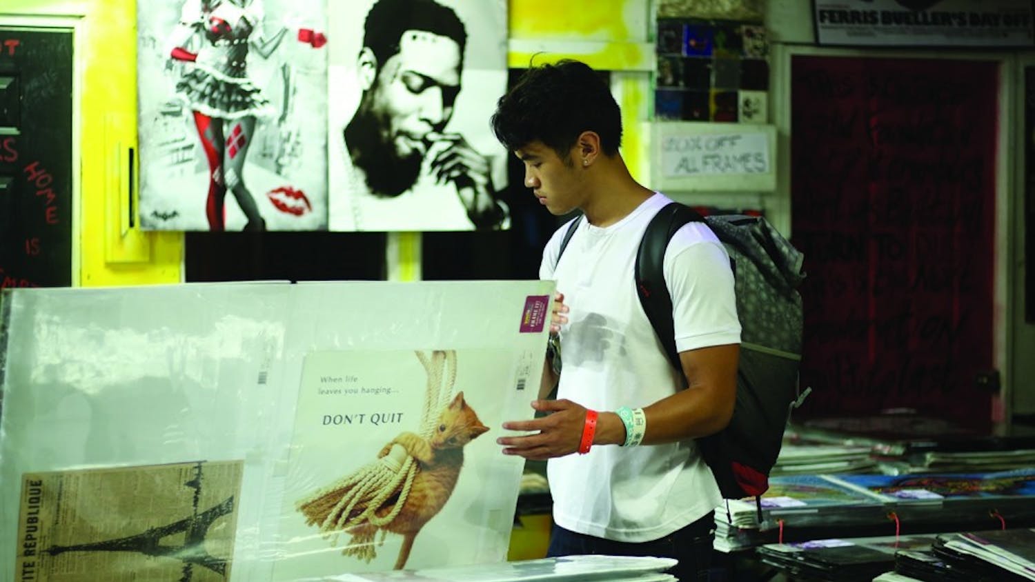 CJ Alfonso, a junior majoring in global studies and public policy, browses the poster sale at the Teen Center on Rosemary St. This poster sale has opened the UNC school year for over twenty years.