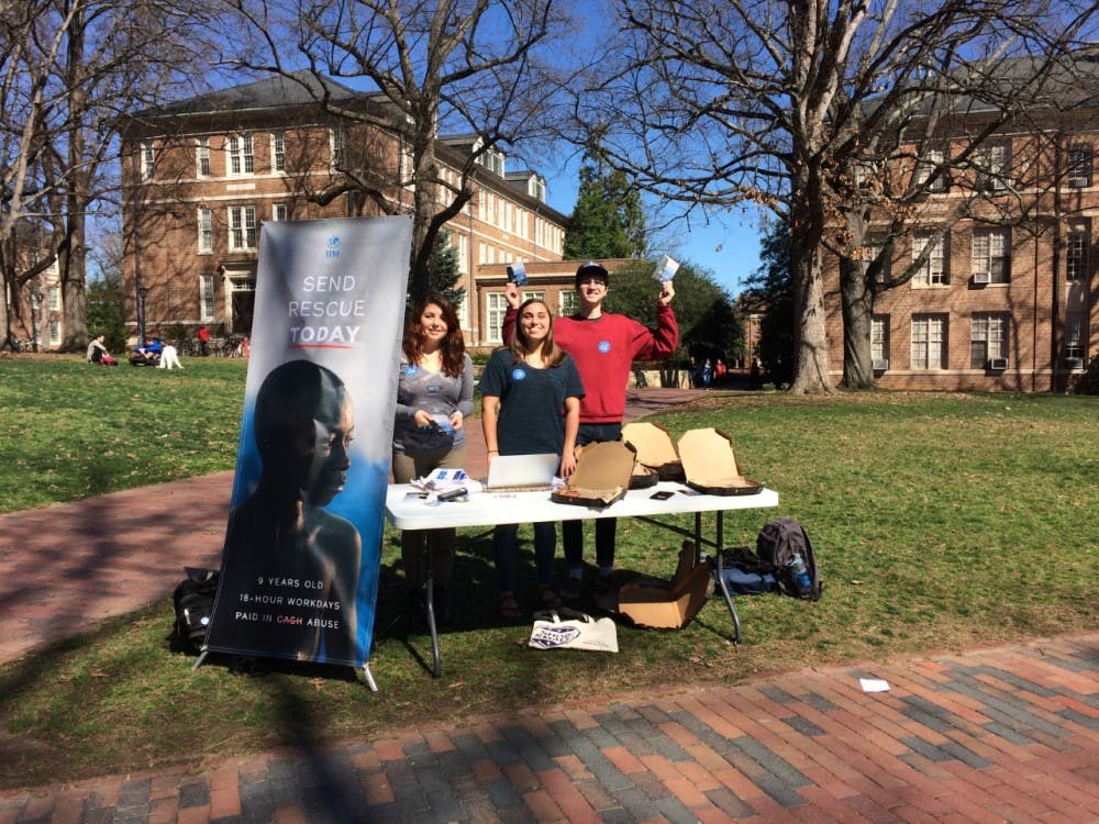<p>Junior Michelle Hugo, senior Mandy Spalding and sophomore Parker Marshall &nbsp;staff a table for UNC's chapter of the International Justice Mission.&nbsp;</p>