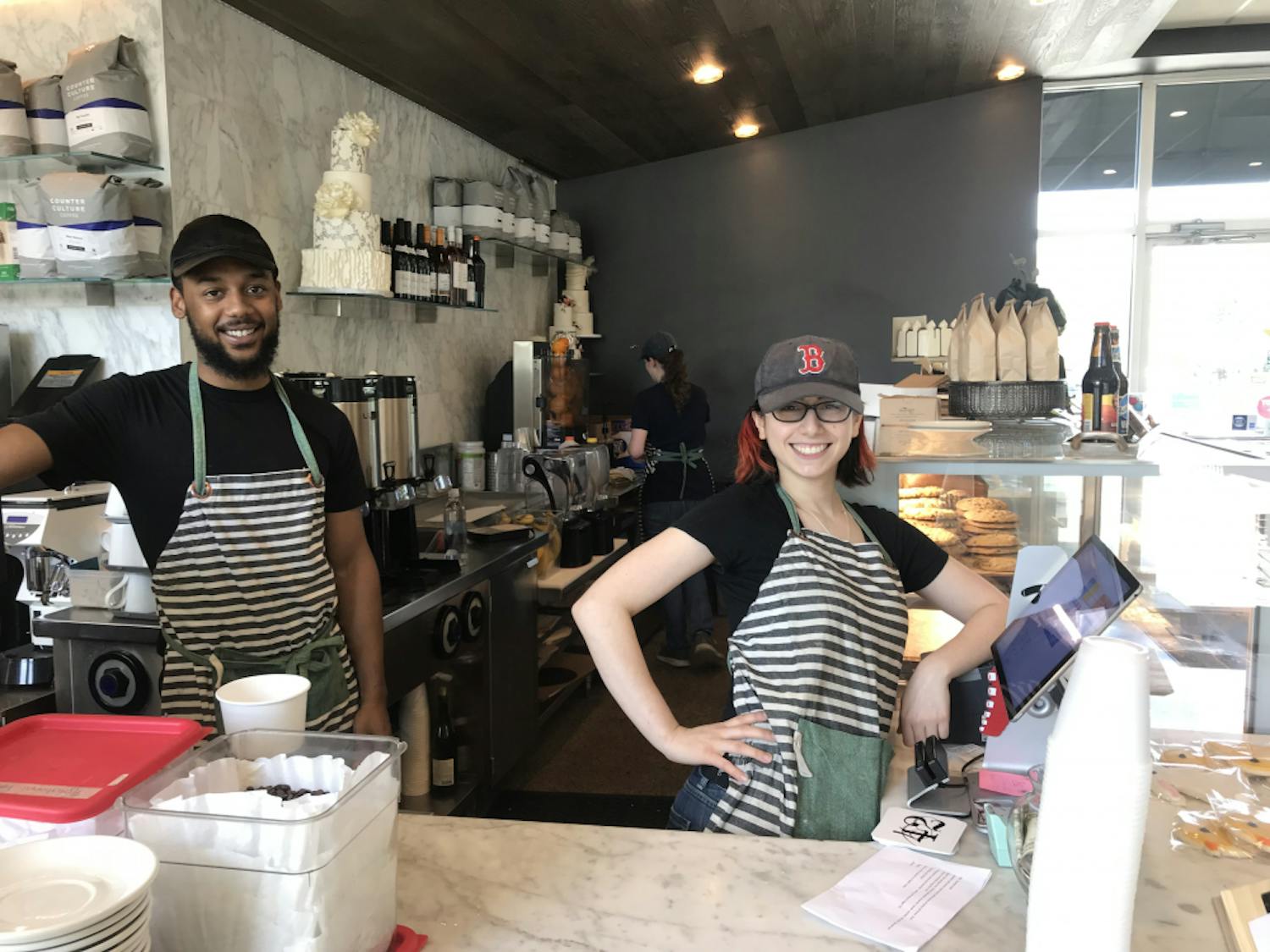 Michael Teasley (left) and Deb Aronin (right), both employees of Mad Hatter's Cafe and Bakeshop in Durham, say their job is to deliver smiles to all the customers. Mad Hatter's is expanding to Chapel Hill and hopes to open a new location on South Campus during the summer of 2019.