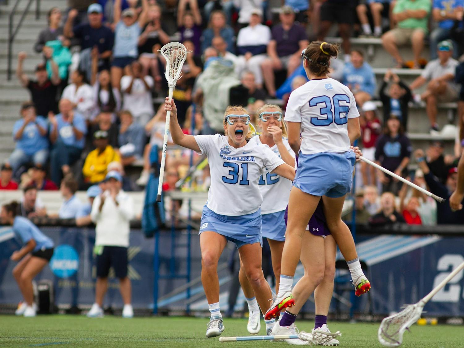 Graduate student attacker Sam Geiersbach (36) celebrates with graduate student attacker Andie Aldave (31) after scoring the tying goal in the fourht quarter of UNC's NCAA Tournament semifinal match against Northwestern at Homewood Field in Baltimore, M.D. on May 27, 2022. UNC won 15-14.