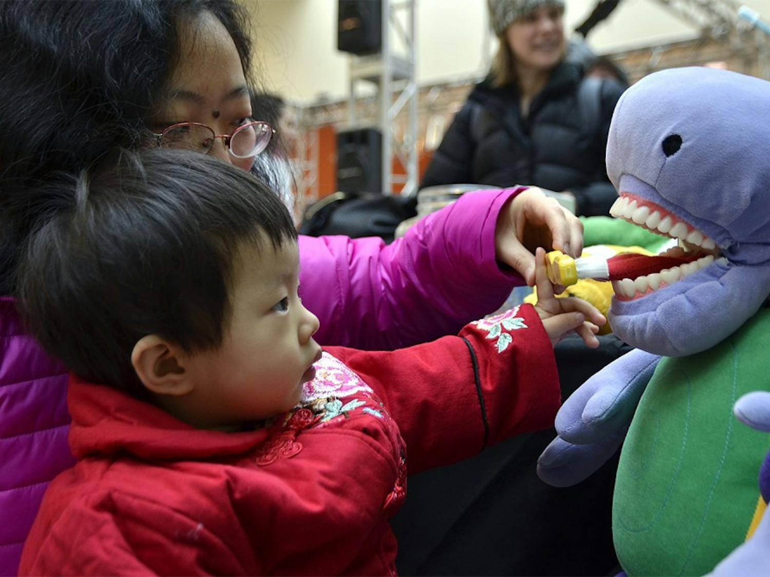 Kidzu Children's Museum partnered with Southern Village Pediatric Dentistry for an event at University Mall on Saturday morning. Carolina K. Wu, 24 months, practices her brushing skills on a stuffed dinosaur.