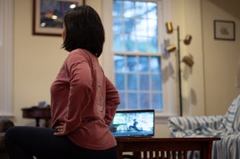 DTH Photo Illustration. A woman does yoga via UNC Campus Recreation Live Restore Yoga class. Campus Rec offers live classes for students in the midst of the coronavirus outbreak.