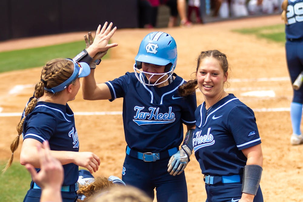 The UNC softball team celebrates at the dugout during the game against Florida State at Anderson Stadium on Saturday, April 16, 2022. UNC won 5-1.