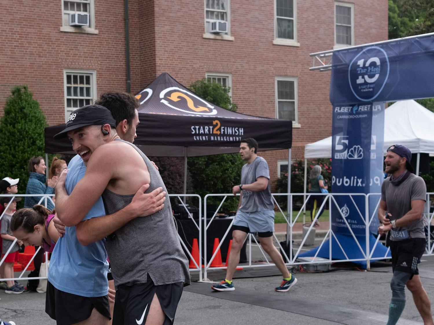 Racers embrace in front of Teague Residence Hall during the Tar Heel Ten Miler on Saturday, April 22, 2023.