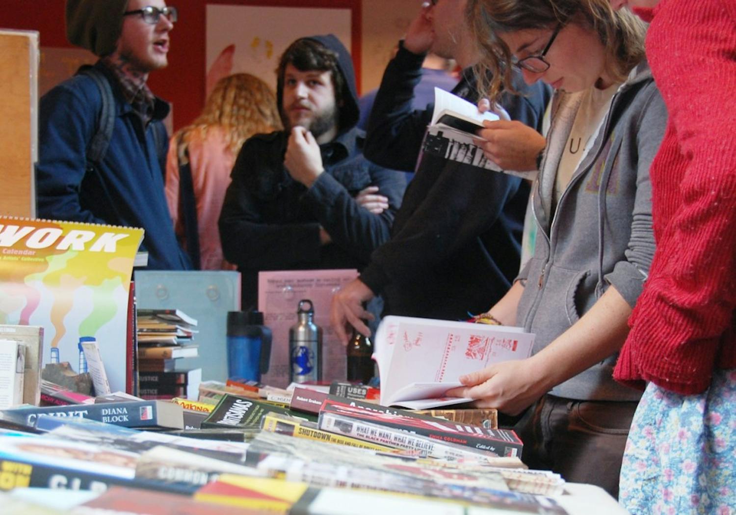 Community members browse through book selections at the area’s first Anarchist Bookfair held at the Nighlight Club on Saturday.
