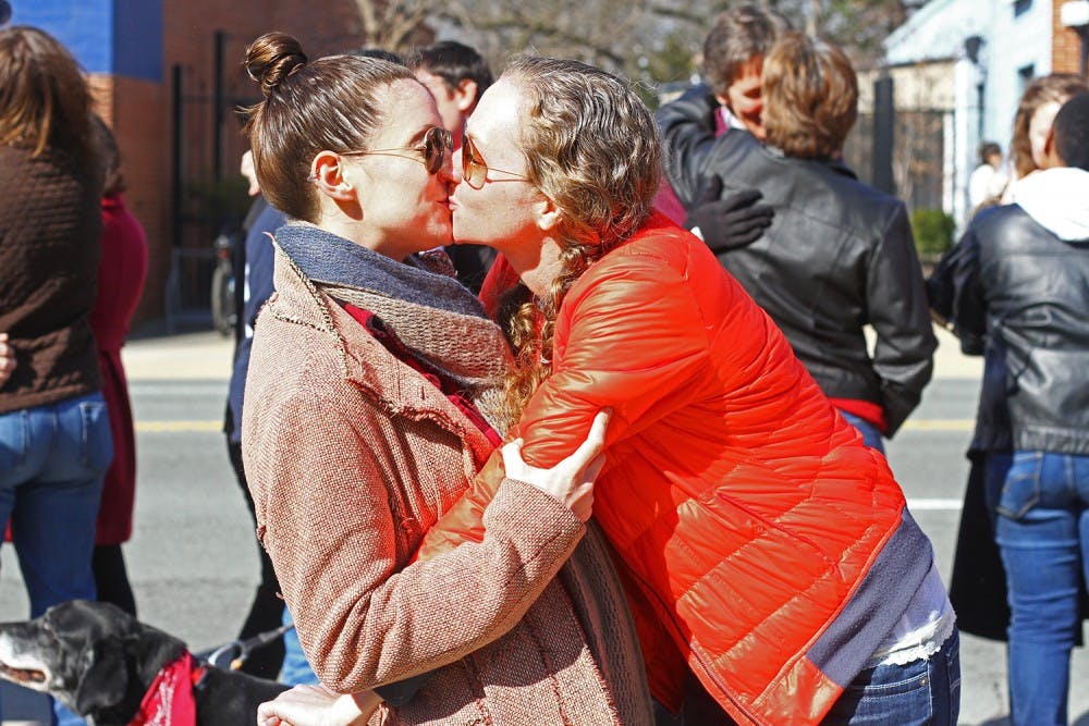 Sarah Owens (right) and Heather Sivaraman, both of Carrboro, kiss on Main Street to advocate for marriage equality on Saturday.