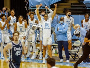 The UNC bench celebrates near the end of the game in the Dean Dome on March 6, 2021. The Tar Heels beat the Blue Devils 91-73.