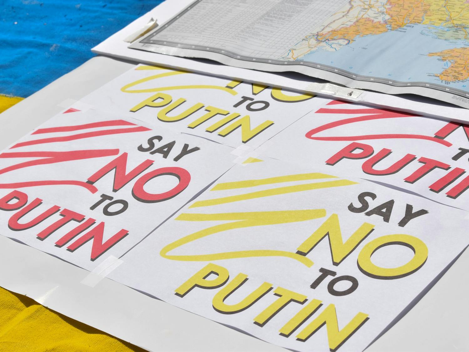 "Say No to Putin" posters lay on tables at the campus rally in solidarity with Ukraine.&nbsp;