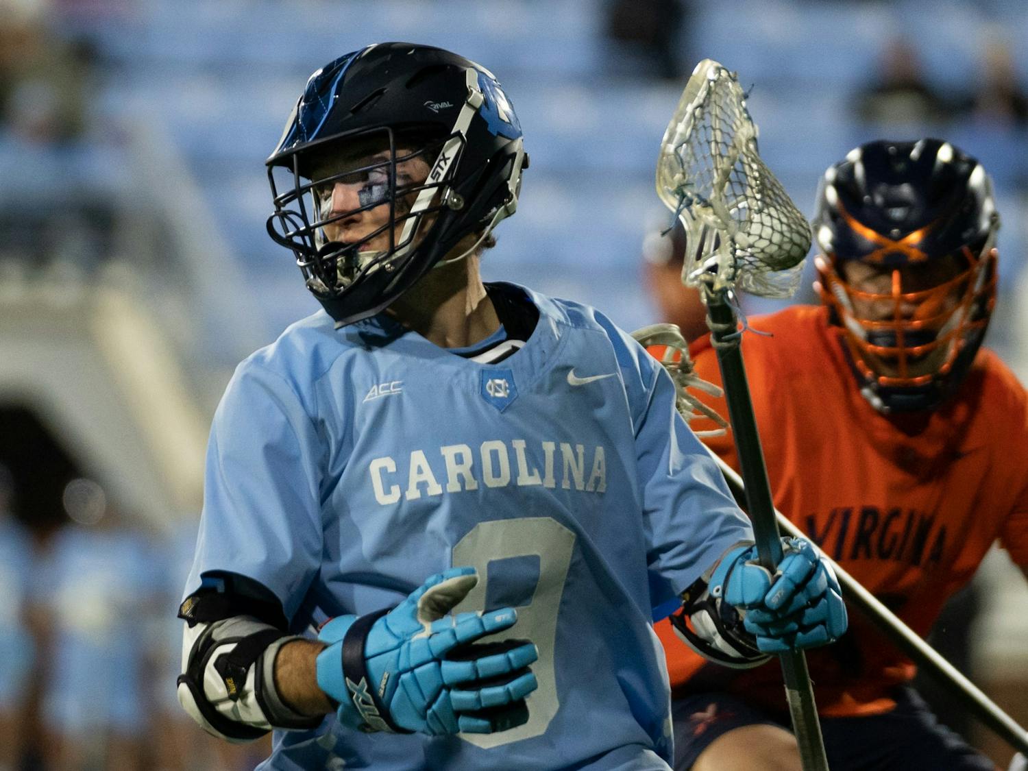 Senior attackman Jacob Kelly (9) cradles the ball during a men's lacrosse game on Dorrance Field against UVA on Thursday, Mar.10, 2022. UNC lost 11-15.