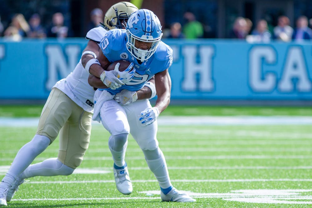 Graduate student running back Ty Chandler (19) runs with the ball at the game against Wofford on Nov. 20 at Kenan Stadium.