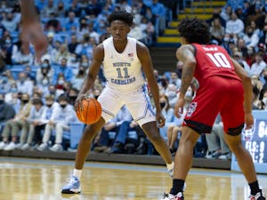 First-year guard D'Marco Dunn (11) controls the ball at the game against NC State at the Smith Center in Chapel Hill on Jan. 29, 2022. UNC won 100-80.