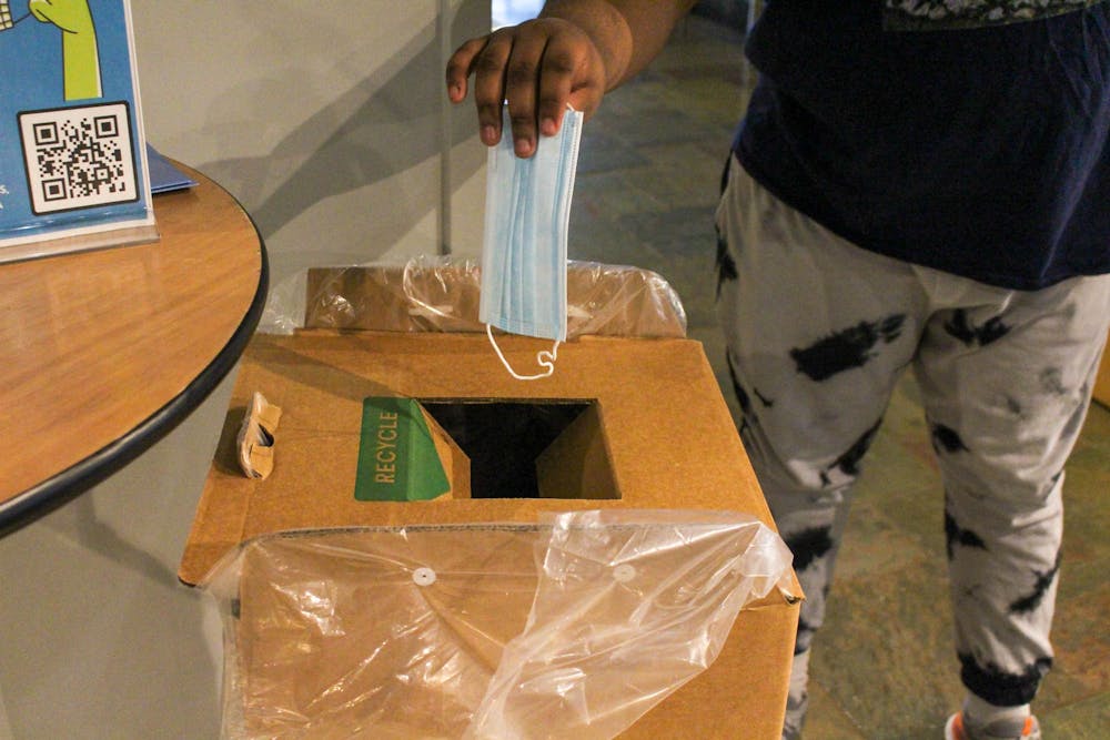 Sophomore business administration major BJ Miles puts a surgical mask in one of the six teracycle boxes sponsored by the UNC Student Government, UNC Green Labs, and Sustainable Carolina. These boxes have been placed on campus for students to recycle surgical, KN95, and N95 masks.