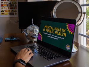 DTH Photo Illustration. A student views mental health facts on the South Asian Public Health Association website.