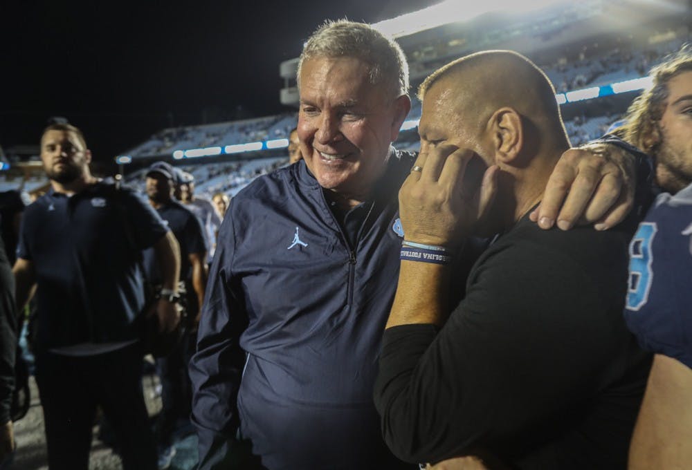 Head Coach Mack Brown and Offensive coordinator Phil Longo celebrate UNC's win on Saturday, Oct. 26, 2019. UNC defeated Duke 20-17.