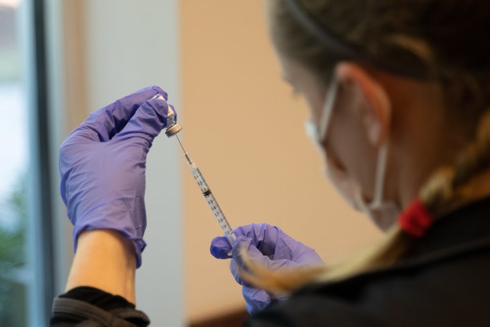 A volunteer fills a syringe with the COVID-19 vaccine at La Semilla's vaccination event, Feb. 20, 2021.