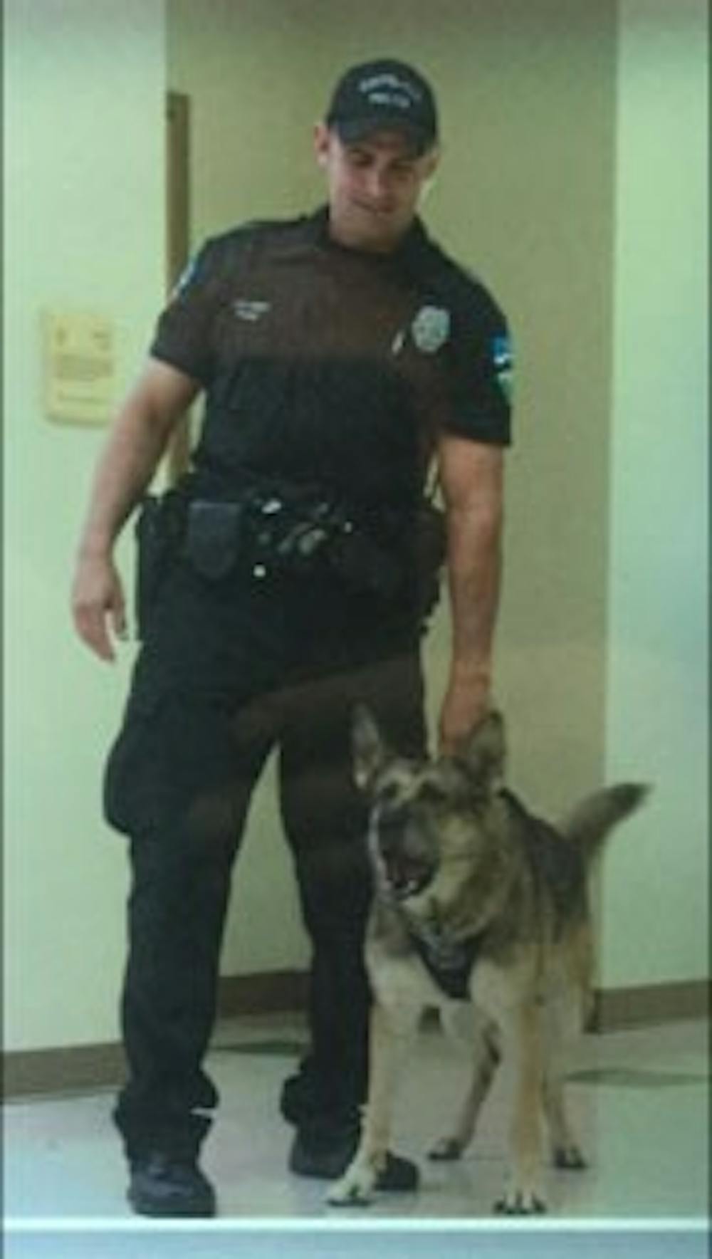MJ barks while being held by her handler, officer David Funk. Photo courtesy of David Funk.