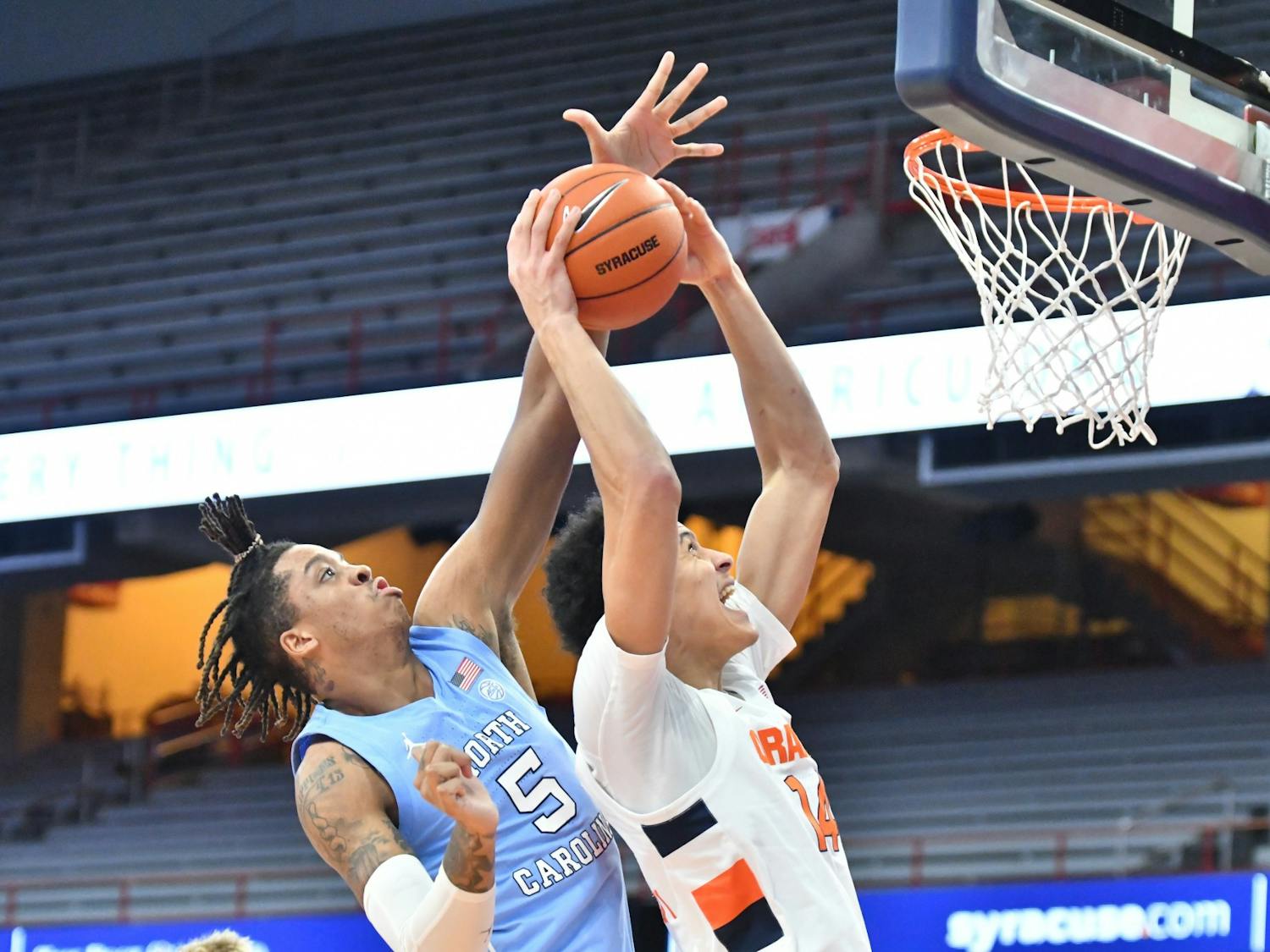 Mar 1, 2021; Syracuse, New York, USA; Syracuse Orange center Jesse Edwards (14) struggles to take a shot as North Carolina Tar Heels forward Armando Bacot (5) applies pressure in the first half at the Carrier Dome. Photo courtesy of Mark Konezny/USA TODAY Sports