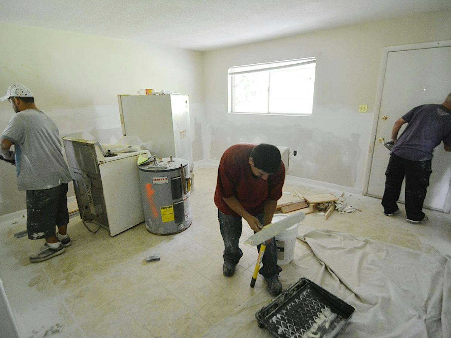 Brothers, Jay Lopez (left), Oscar Lopez, and Luis Lopez work on renovating the condemned apartments at Camelot Village.