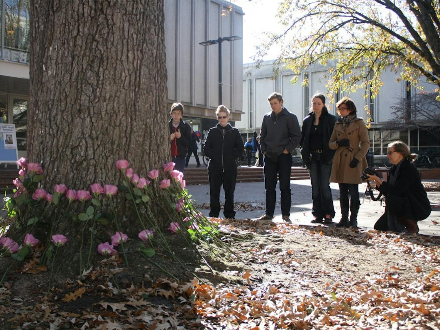 A group of on lookers pay their respects to those who have been persecuted because of their gender on Transgender Remembrance day, Wednesday afternoon in the Pit. 