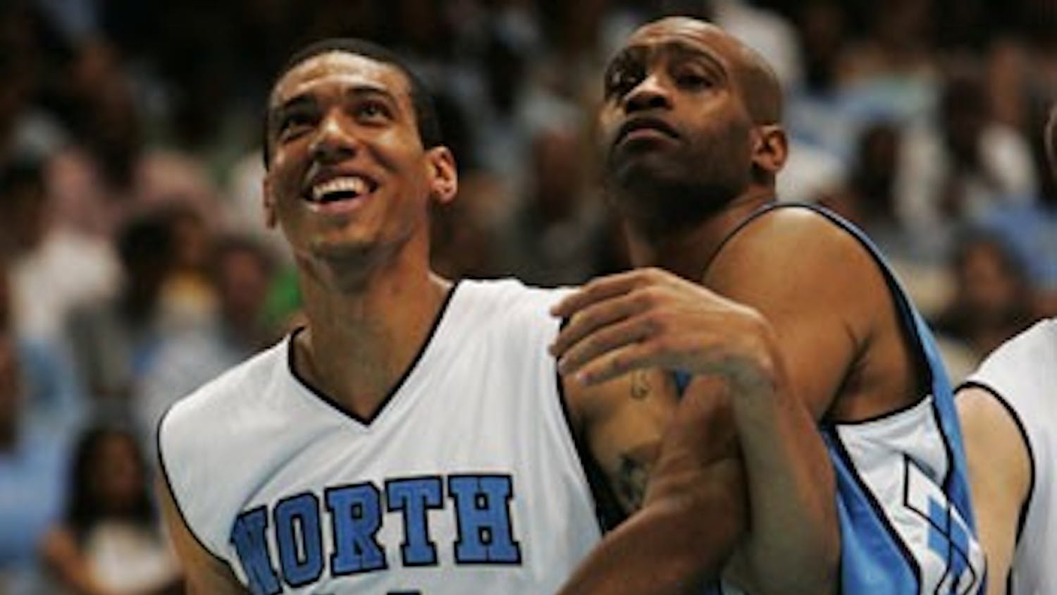 Former UNC players Danny Green (left) and Vince Carter goof off during a foul shot during UNC’s alumni game Friday night.