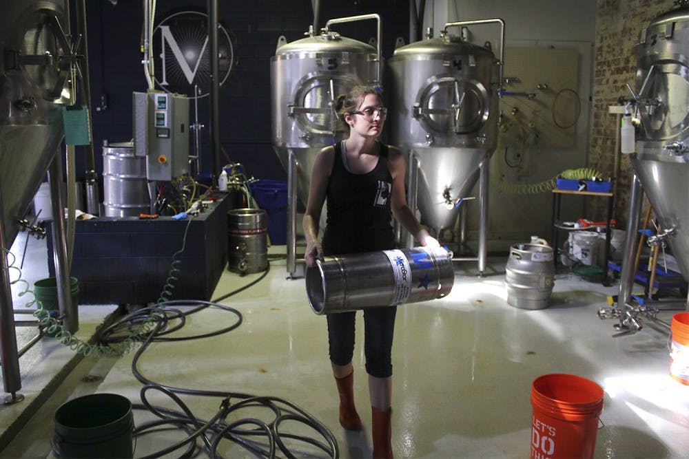 22 companies collaborated this weekend to create the North Carolina state beer at Mystery Brewing Company in Hillsborough. Erica Tieppo, from Detroit, Michigan, works with the beer through its fermentation process.