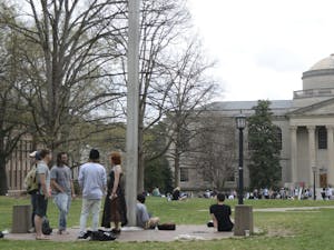 Students smoke and converse around the flagpole on the Lower Quad. 