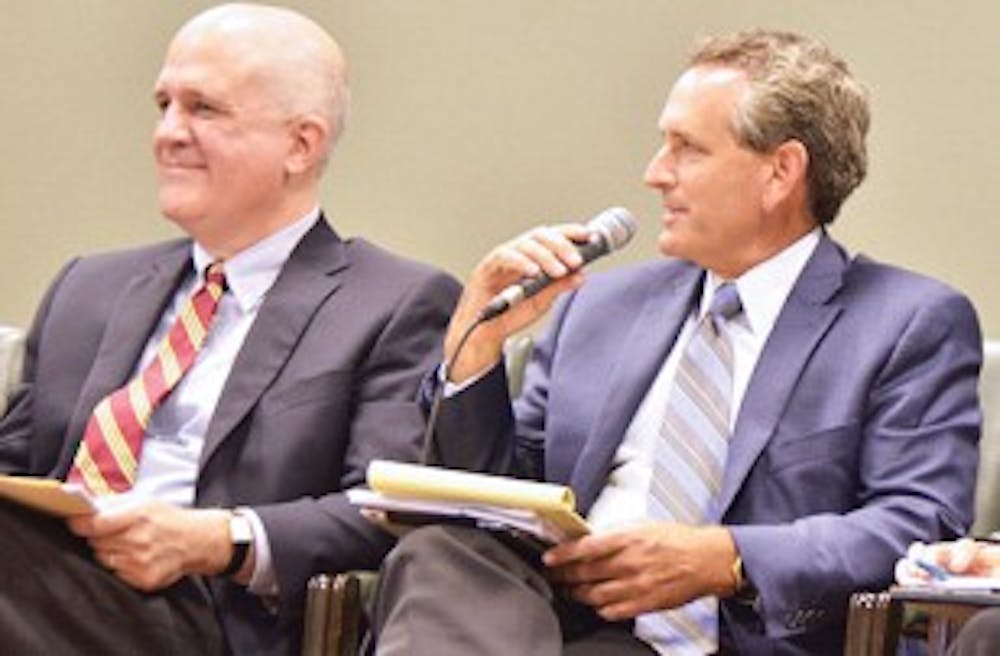 <p>(From Left) Bubba Cunningham and Admissions Dean Steve Farmer discuss athletics at a Faculty Council meeting.</p>