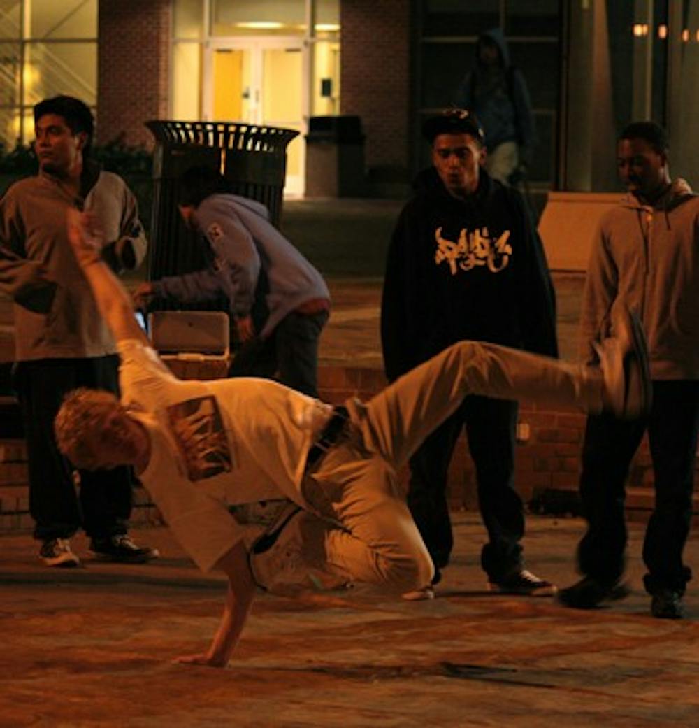 Andrey Belostotsky, a senior business major, breakdances in the Pit at night. 