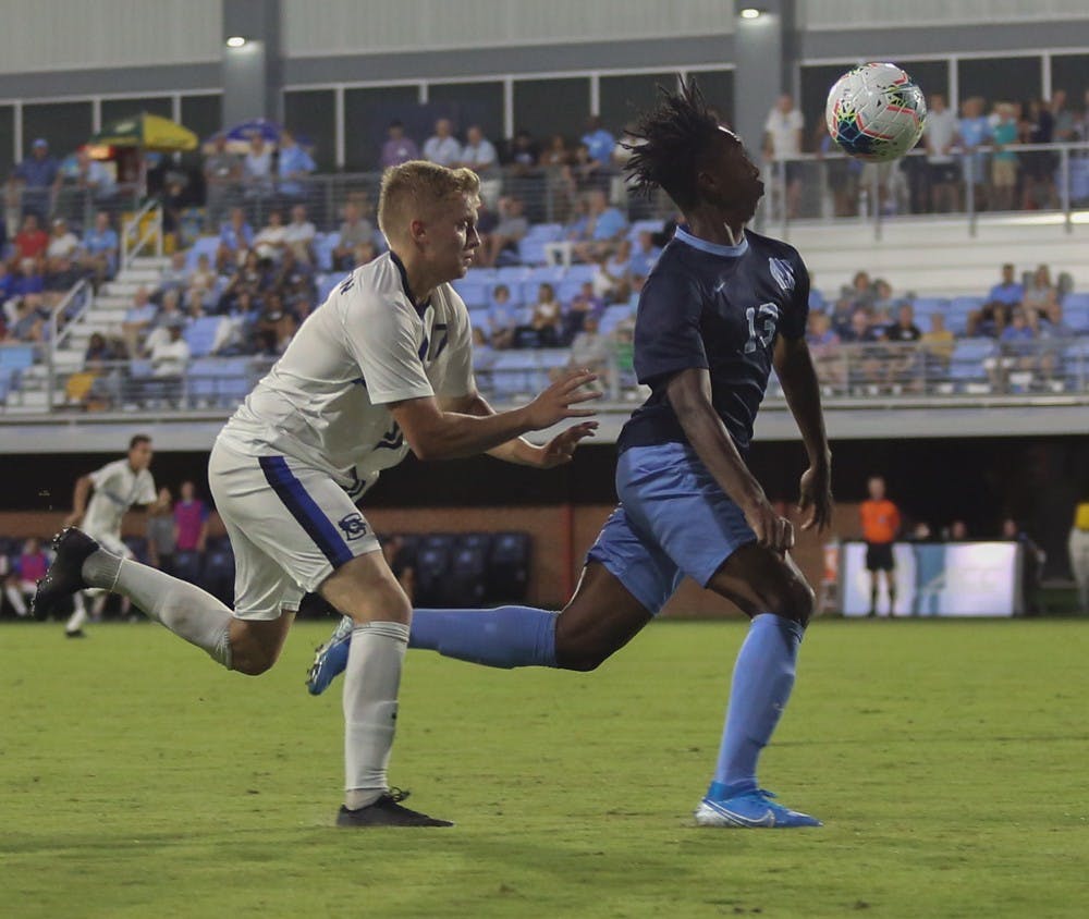 <p>UNC first-year forward Key White (13) races to beat Creighton University's sophomore midfielder Keegan Boyd (17) to gain possession during Friday night's 2-2 tie.</p>