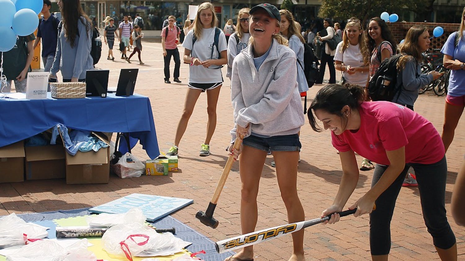 Amanda Roth (left) and Emili Hall, both juniors, participate in Southern Smash, an event hosted by UNC Panhellenic Council that allows participants to break scales that represent the things that weigh them down.