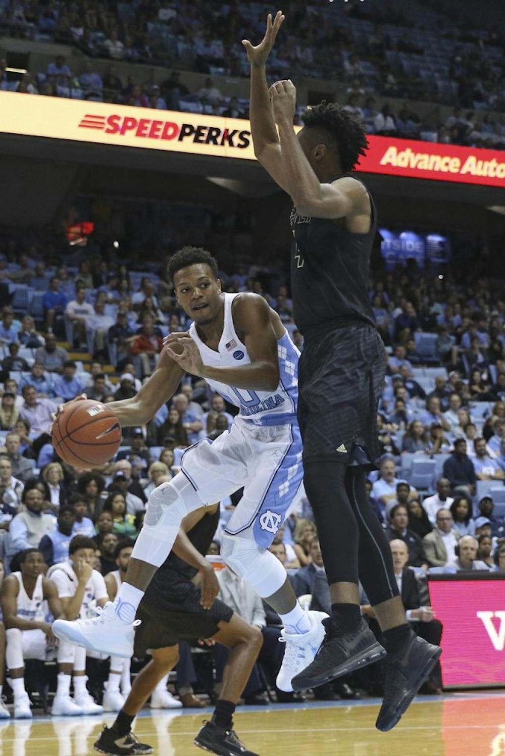 <p>UNC guard Nate Britt (0) looks to pass the ball around a UNC-Pembroke defender on Friday.&nbsp;</p>