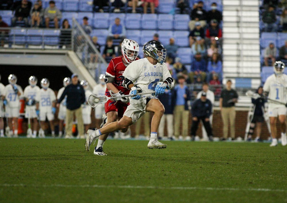 Graduate attackman Chris Gray (4) sprints past his defender to the goal on February 11, 2022 at Dorrance Field. UNC won their season opener against Richmond 13-9. 