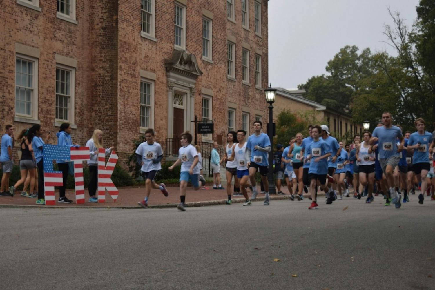 Two young runners sprint away from the starting line and lead the pack of runners during the Carolina for the Kids annual 5K and Fun Run on Sunday.